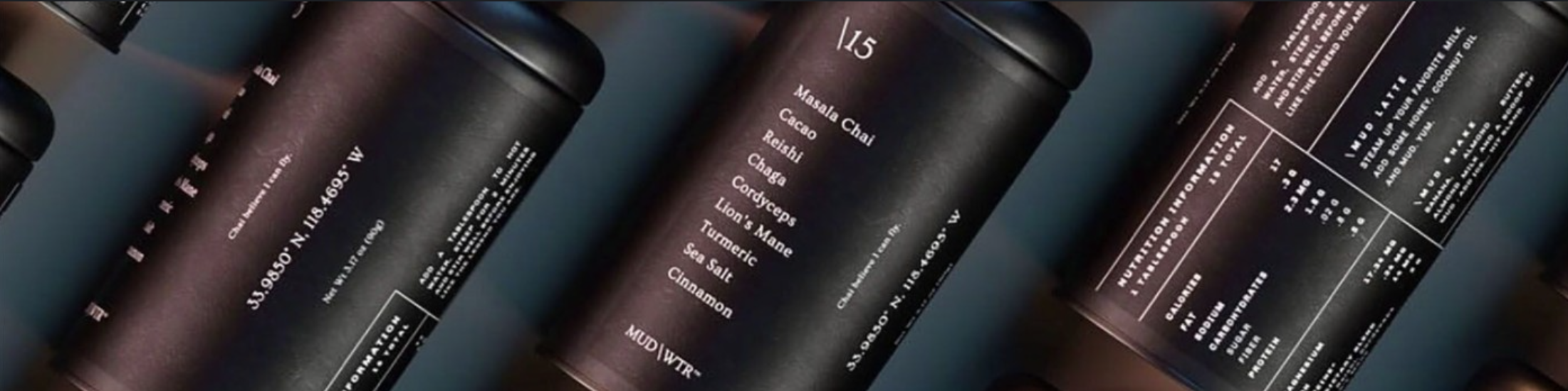 MUD/WTR tins arranged in a dark product composition